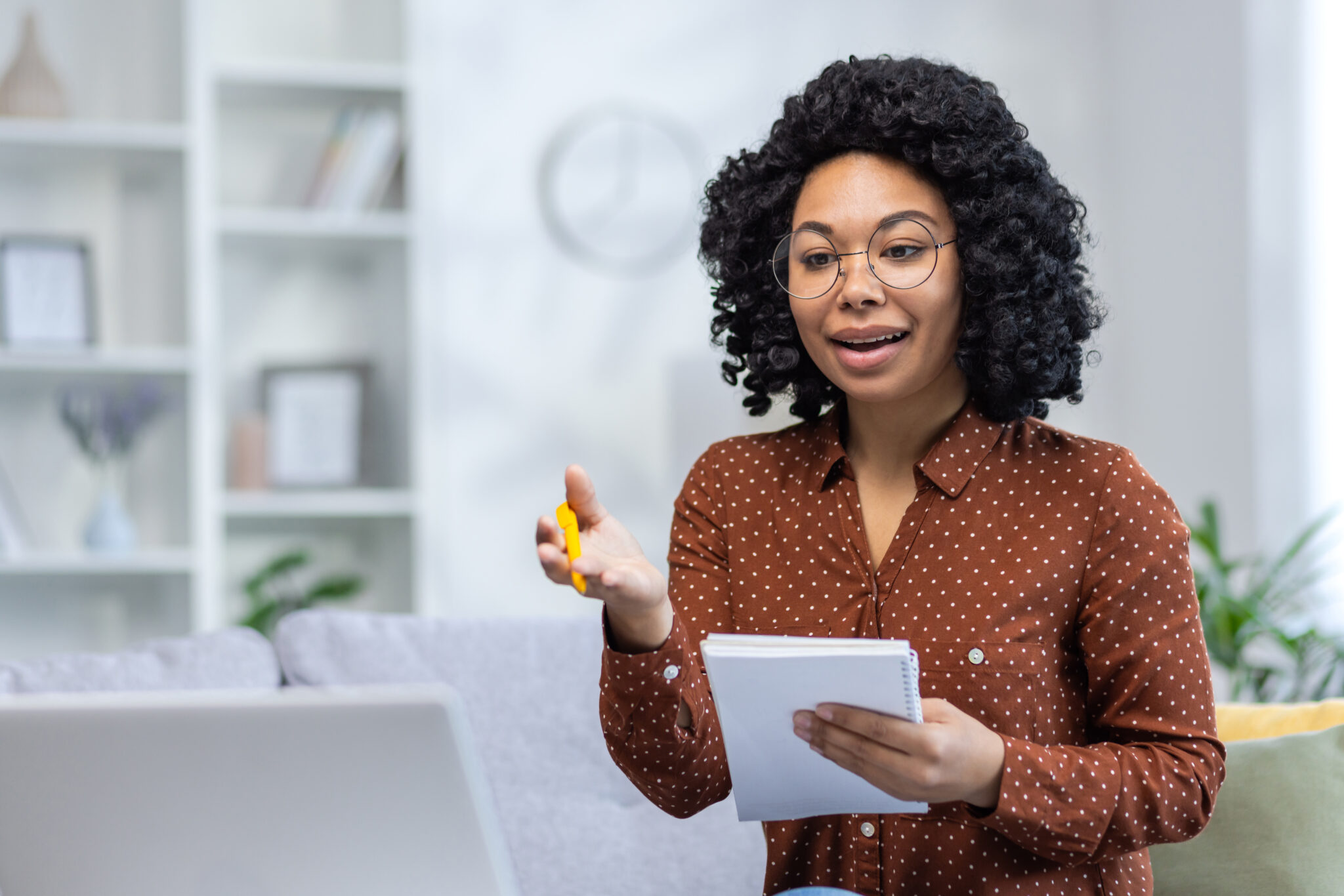 Woman holding a tablet and gesturing during a video call.